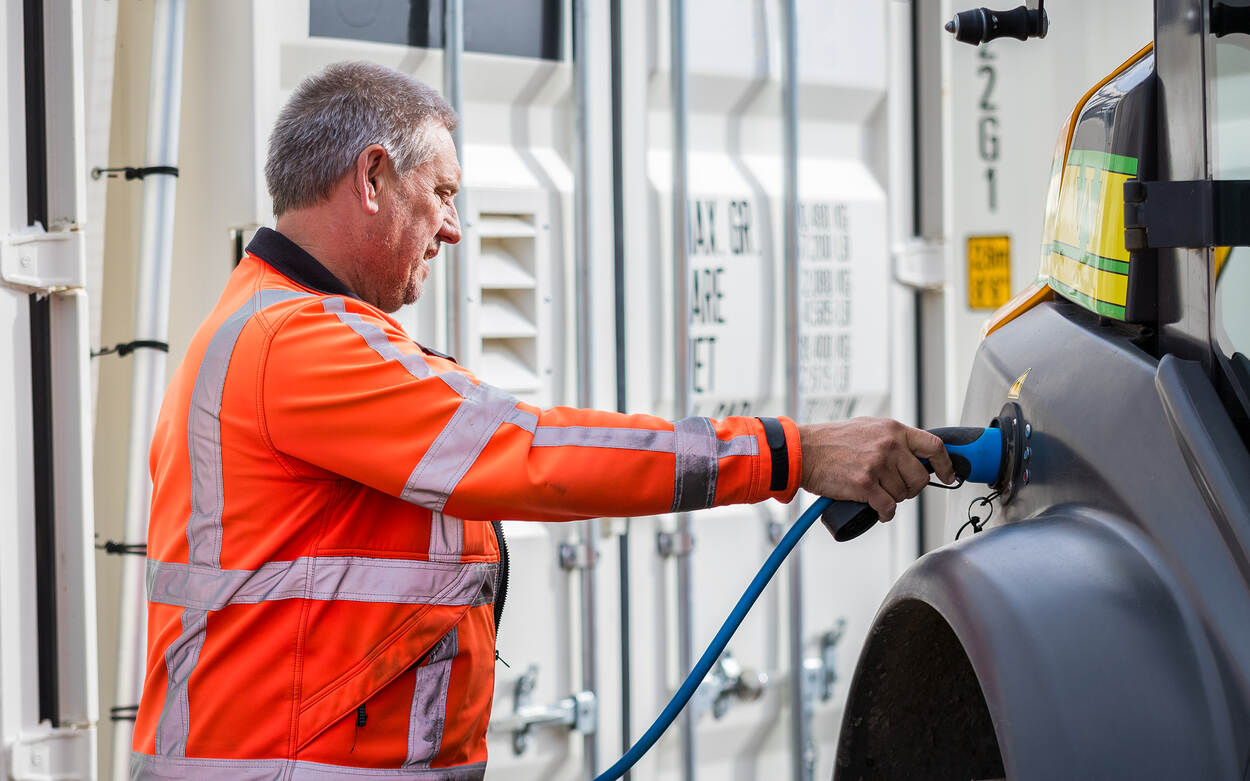 Bouwmedewerker stopt stekker in elektrische machine