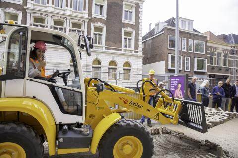 Wethouder duurzaamheid Glimina Chakor voert de starthandeling uit in graafmachine Groningen